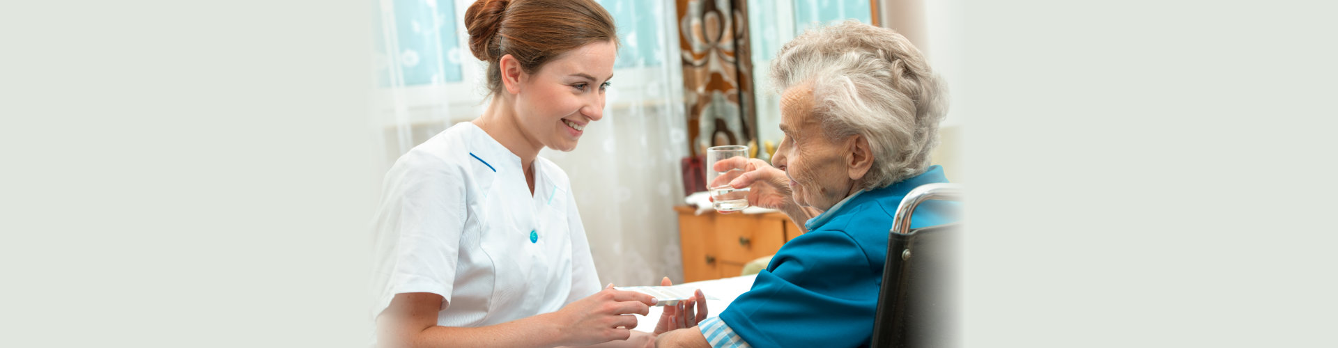 female nurse giving senior woman medical pills