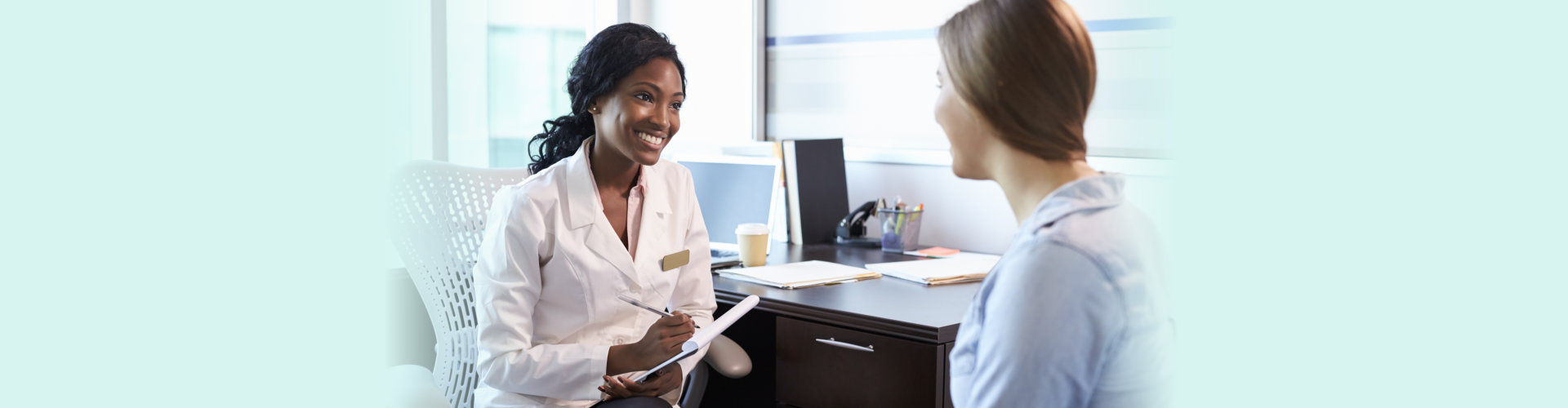 Doctor In Consultation With Female Patient In Office