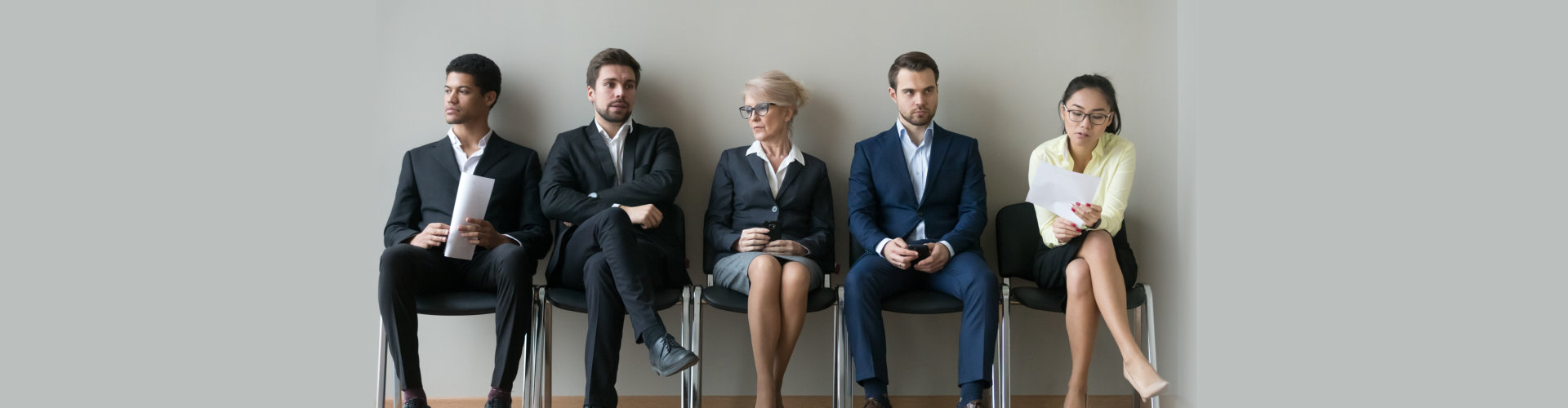 Diverse business people applicants sit in row line queue waiting for their turn